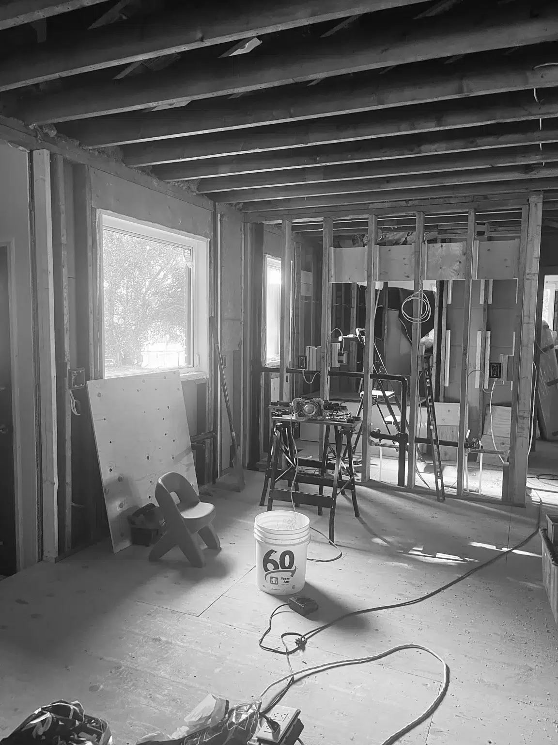 The early stage of a renovation, with walls stripped to the studs and tools set up for work.