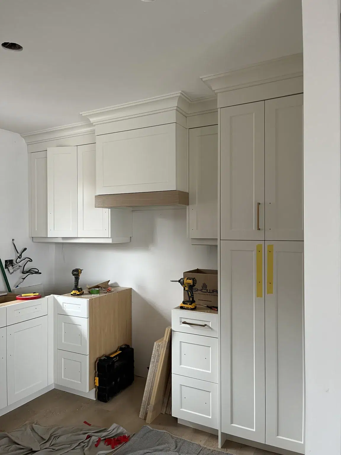 The stove area of a modern white kitchen undergoing renovation.