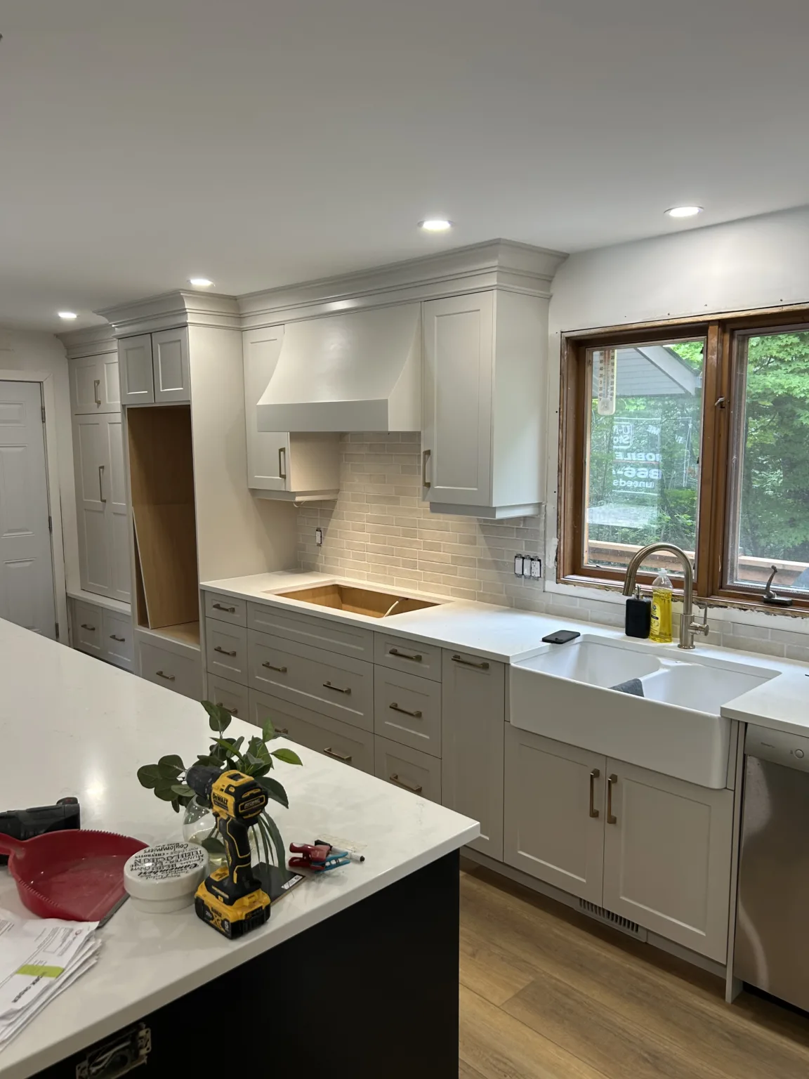 A sleek white kitchen in the midst of a renovation.